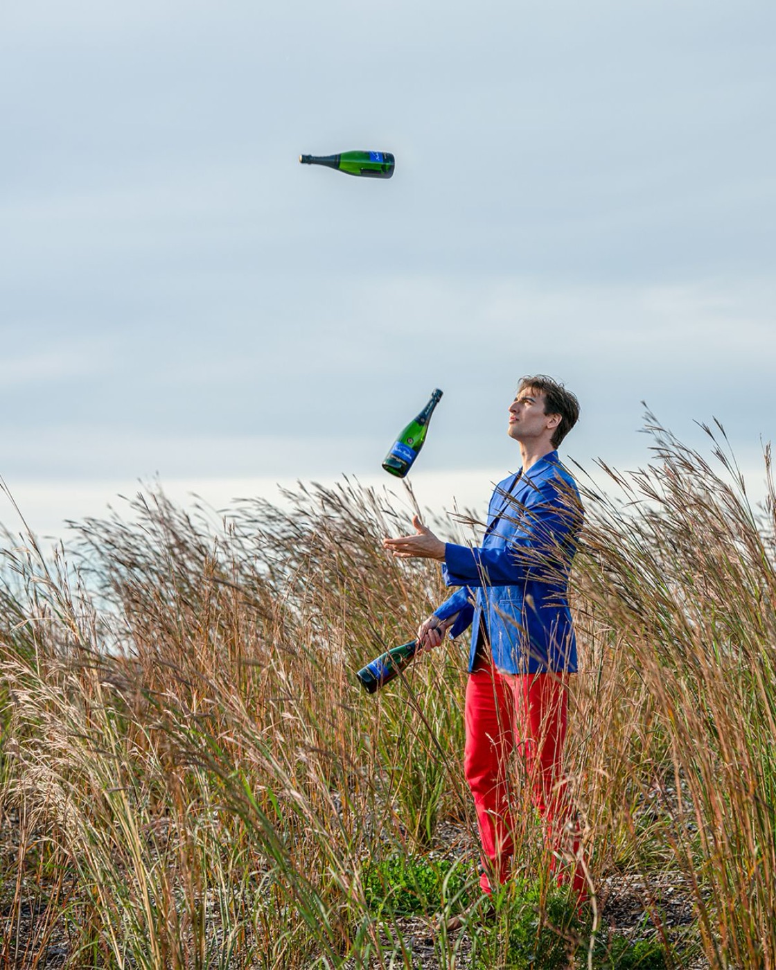 Louis-Philippe Jodoin jonglant avec des bouteilles en plein air